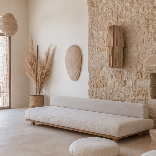 Neutral living room with a curved sofa, natural stone wall, and warm textured decor